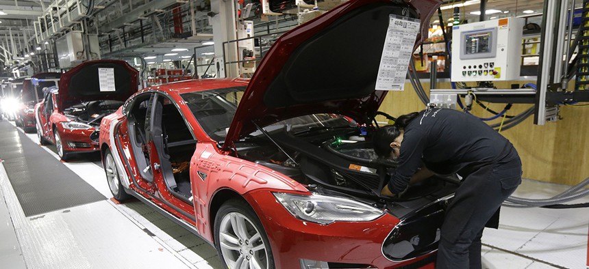 Tesla employees work on a Model S cars in the Tesla factory in Fremont, Calif., Thursday, May 14, 2015.