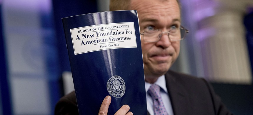 Budget Director Mick Mulvaney holds up a copy of President Donald Trump's proposed fiscal 2018 federal budget.