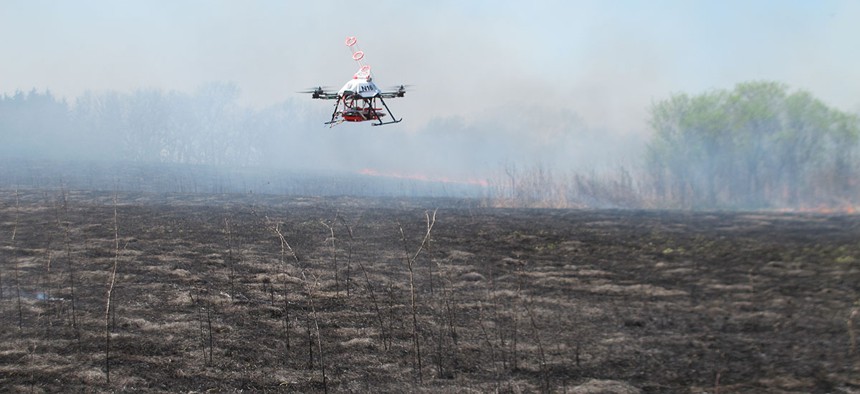 A drone designed to ignite controlled grass fires comes in for a landing in a field at the Homestead Monument of America in Beatrice, Neb., on Friday, April 22, 2016.