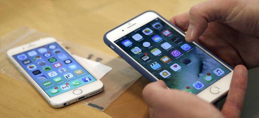 A customer sets up his new iPhone 7 Plus, right, as he switches from the iPhone 6 at the Apple Store.