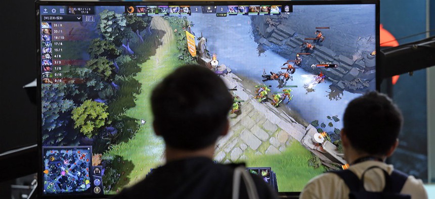 A monitor shows the game as fans look on at KeyArena during the International Dota 2 Championships Wednesday, Aug. 9, 2017, in Seattle. 