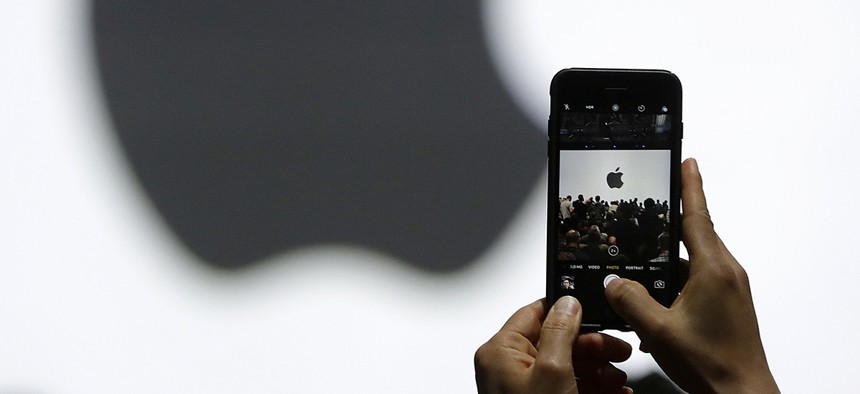 A person takes a photo of an Apple logo before an announcement of new products at the Apple Worldwide Developers Conference on June 5, 2017. 