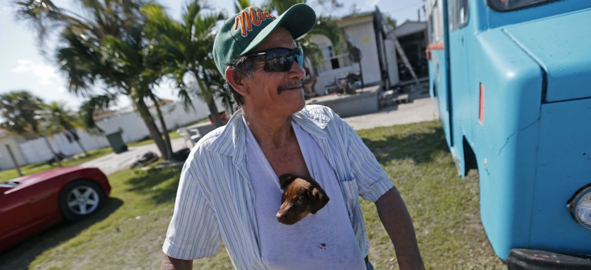 Nicolas Perez keeps a puppy he named "Irma," stuffed in his shirt, who he rescued from flooding in the aftermath of Hurricane Irma, in Immokalee, Fla. 