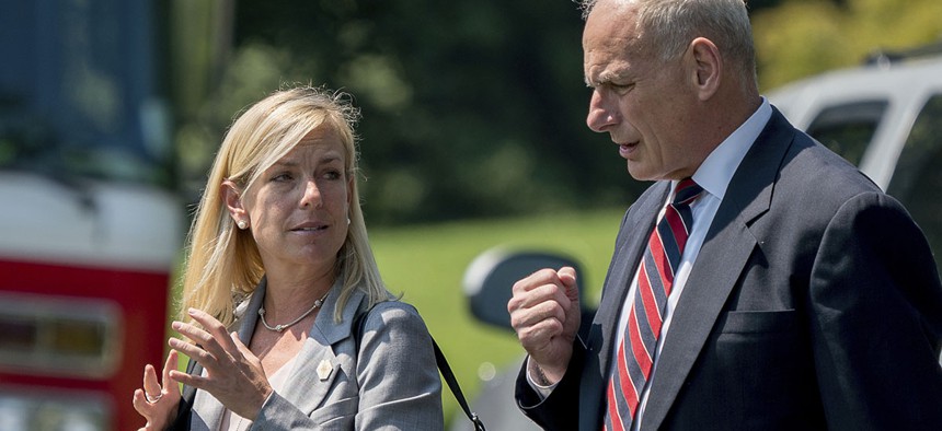White House Chief of Staff John Kelly and Kirstjen Nielsen speak together as they walk across the South Lawn of the White House in Washington, Tuesday, Aug. 22, 2017