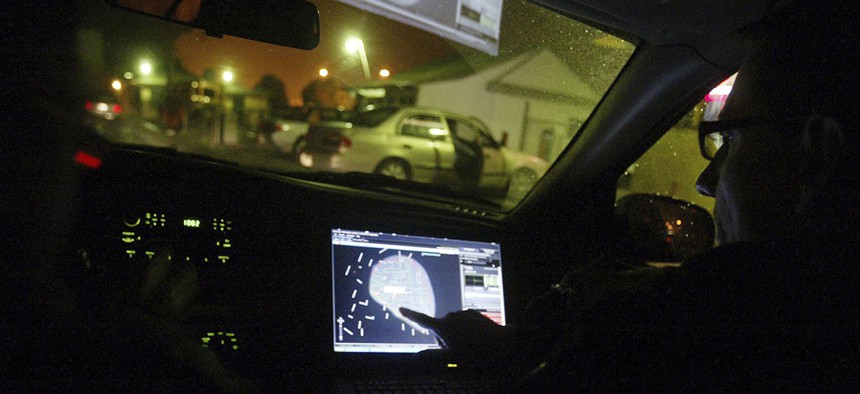 A person points at a GPS inside a vehicle on a residential street. An engineer alerts police of a gunshot detected with a ShotSpotter system in East Palo Alto, California.