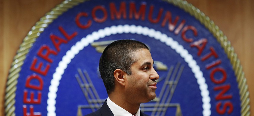 After a meeting voting to end net neutrality, FCC Chairman Ajit Pai smiles while listening to a question from a reporter, Thursday, Dec. 14, 2017.