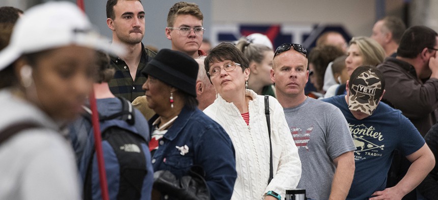 People wait in line to rebook flights at Hartfield-Jackson Atlanta International Airport , Monday, Dec. 18, 2017.
