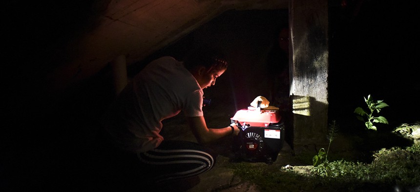 resident Karina Santiago Gonzalez works on a small power plant in Morovis, Puerto Rico. 