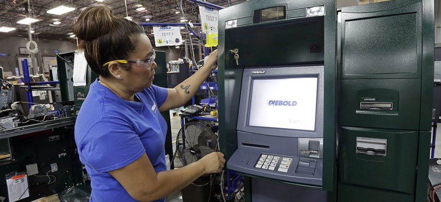 Employee Maria Edney installs software onto an automated teller machine during the manufacturing process at Diebold Nixdorf in Greensboro, N.C. 