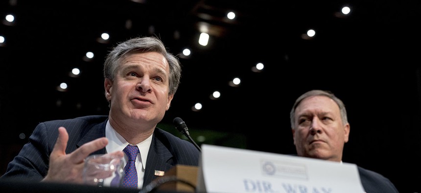 FBI Director Christopher Wray, accompanied by CIA Director Mike Pompeo, right, speaks at a Senate Select Committee on Intelligence hearing on worldwide threats, Tuesday, Feb. 13, 2018.