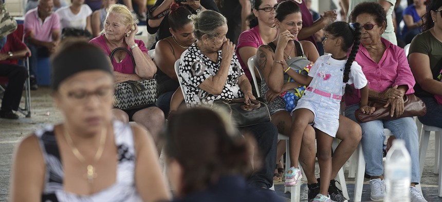 People wait at the Jose de Diego Elementary School to file FEMA forms for federal aid in the aftermath of Hurricane Maria in Las Piedras, Puerto Rico, Monday, Oct. 2, 2017.