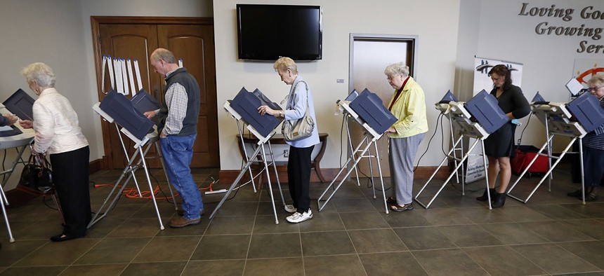 Voters fill the electronic voting machines to cast their ballots during the primary election at the precinct in the Highland Colony Baptist Church in Madison, Miss., on Tuesday, March 8, 2016.