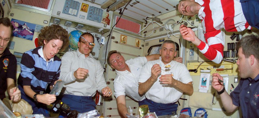 The crew of shuttle mission STS-110 eats dinner
