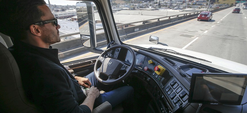 Matt Grigsby, senior program engineer at Otto, takes his hands off the steering wheel of a self-driving, big-rig truck during a demonstration on the highway, in San Francisco. 