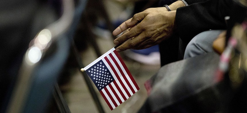 Rupinder Garha, an immigrant from India, holds a small U.S. flag during a naturalization ceremony at the Los Angeles Convention Center, Wednesday, Feb. 15, 2017, in Los Angeles.