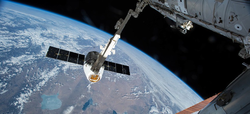 The Canadarm 2 reaches out to capture the SpaceX Dragon cargo spacecraft for docking to the International Space Station. 