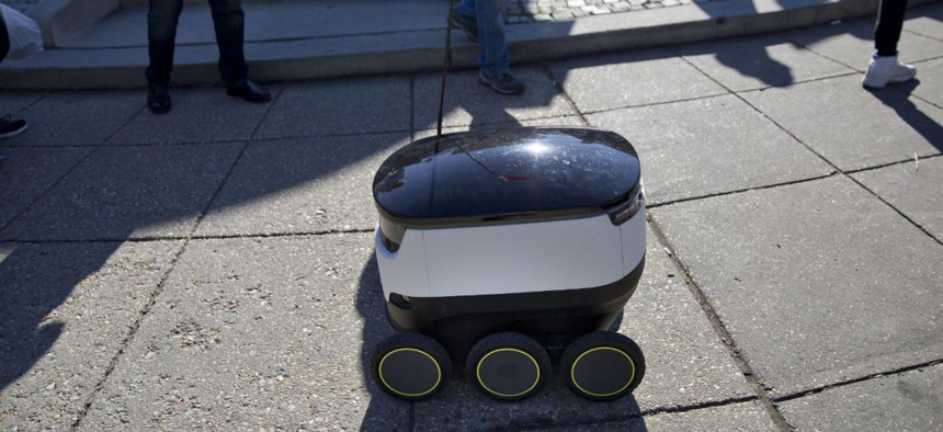 Six-wheeled ground delivery robot, from Estonia-based Starship Technologies, share the sidewalk with pedestrians at DuPont Circle, February 2017 in Washington. 
