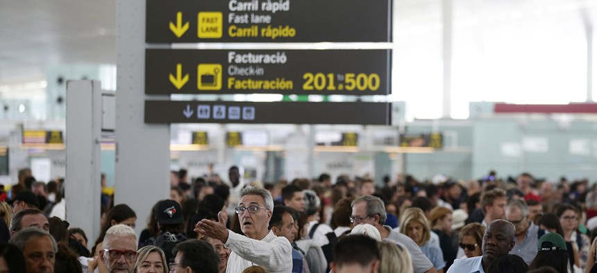 Passengers wait for pass the security control at Barcelona airport in Prat Llobregat, Spain, Friday, Aug. 11, 2017.