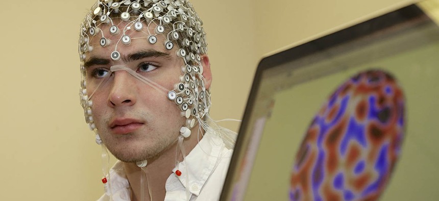 In this May 31, 2013, photo, research assistant Kevin Real wears an EEG net for detecting brain activity which is hooked up to a monitor, at the University of Nebraska's Center for Brain, Biology and Behavior in Lincoln, Neb.