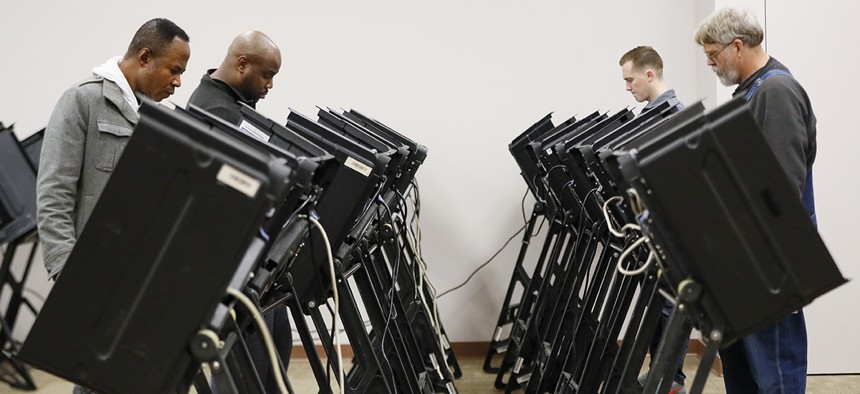 Voters use electronic polling machines as they cast their votes early at the Franklin County Board of Elections, Wednesday, Oct. 31, 2018, in Columbus, Ohio.