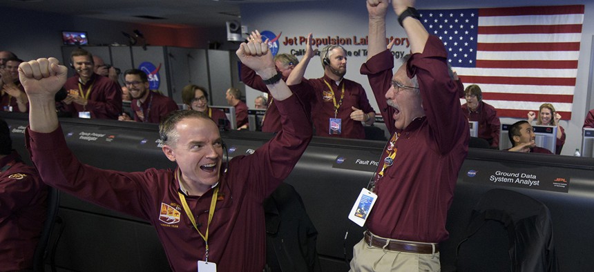 Mars InSight team members Kris Bruvold, left, and Sandy Krasner rejoice, Monday, Nov. 26, 2018, inside the Mission Support Area at NASA's Jet Propulsion Laboratory in Pasadena, Calif.