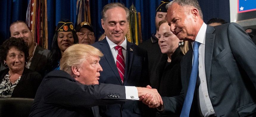 Before signing a bill, President Donald Trump shakes hands with Isaac Perlmutter, CEO of Marvel, in Washington, DC. 