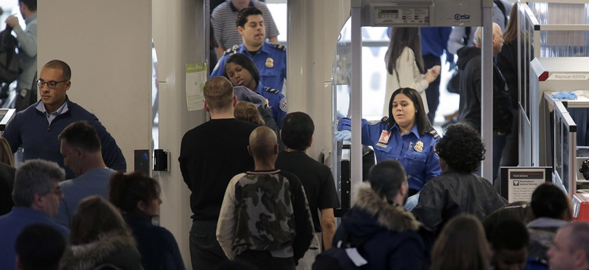 Transportation Security Administration agents help passengers through a security checkpoint at Newark Liberty International Airport in Newark, N.J., Monday, Jan. 7, 2019.