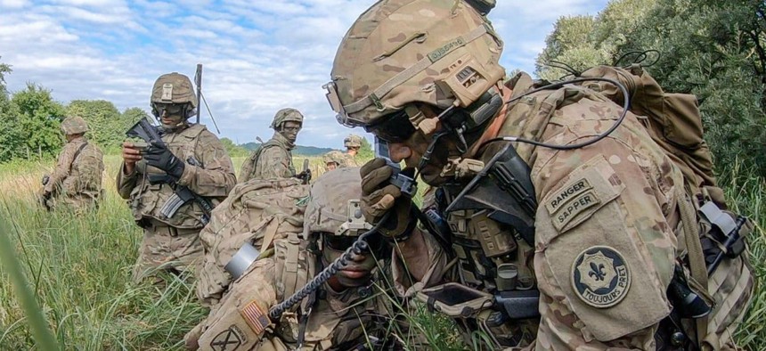 A captain provides a status update to his higher command using his radio transmission operator and the Nett Warrior system in the vicinity of Lithuania in June.