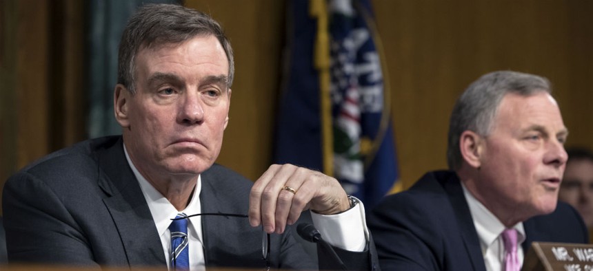 Sen. Mark Warner, D-Va., left, at a hearing about security clearances last March.