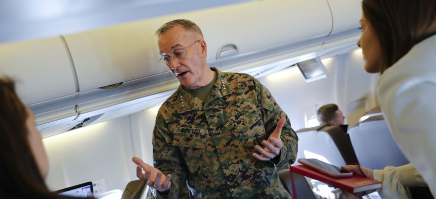 Joint Chiefs Chairman Gen. Joseph Dunford gestures while speaking to reporters during a briefing on a military aircraft before arrival at El Paso International airport in February.