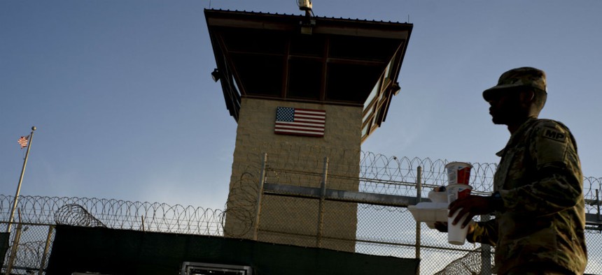 A task force member walks past the Camp VI detention facility at the Guantanamo Bay U.S. Naval Base, Cuba in 2018.