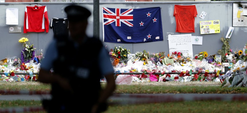 A policeman stands guard near the Al Noor mosque during Friday prayers at Hagley Park in Christchurch, New Zealand, March 22.