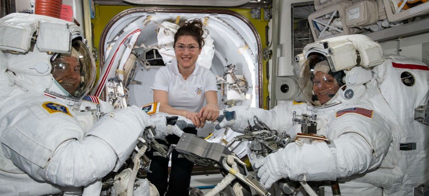 NASA astronaut Christina Koch (center) assists fellow astronauts Nick Hague (left) and Anne McClain in their U.S. spacesuits shortly before they begin the first spacewalk of their careers. 