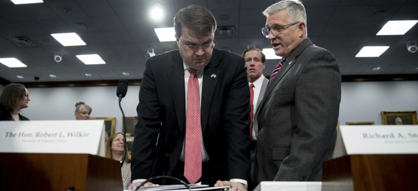 Veterans Affairs Secretary Robert Wilkie, left, speaks with Veterans Health Administration Executive in Charge, Dr. Richard Stone, at a Congressional hearing March 27.