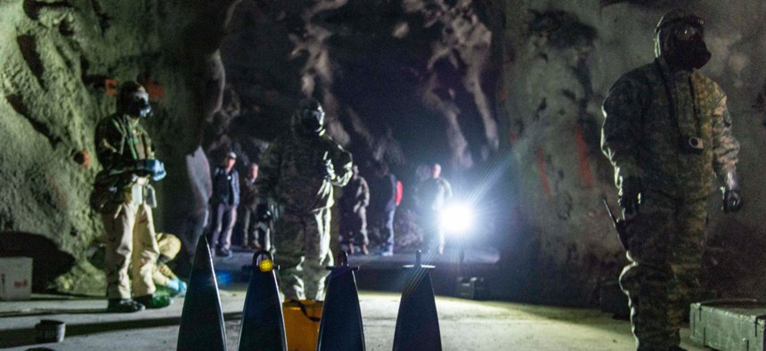 Scientists watch soldiers sample simulated leaking chemical weapons in an underground facility in order to get a better idea of both the bulky protective gear soldiers must wear as well as the dark, constrained environments they sometimes work in.
