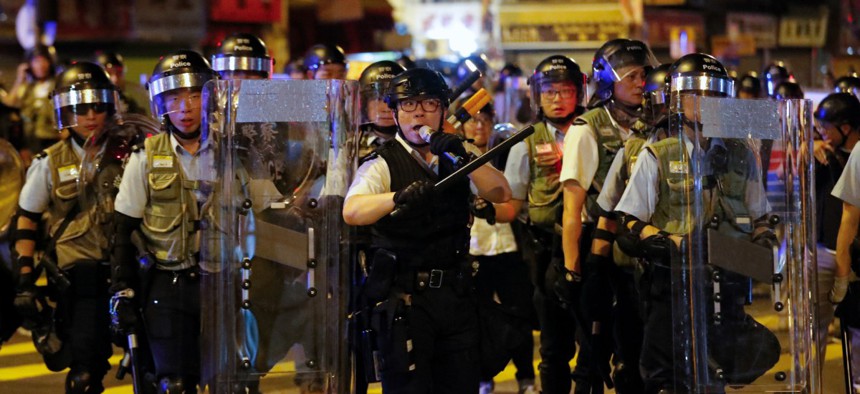 A policeman uses a speakerphone to ask residents and protesters to disperse during a protest at Sham Shui Po district in Hong Kong, Aug. 7.