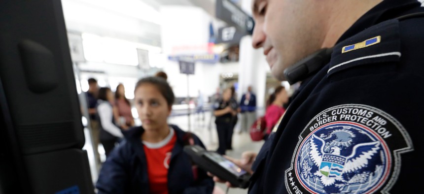 A Customs and Border Protection officer helps a passenger navigate a facial recognition kiosks at George Bush Intercontinental Airport in Houston in 2017.