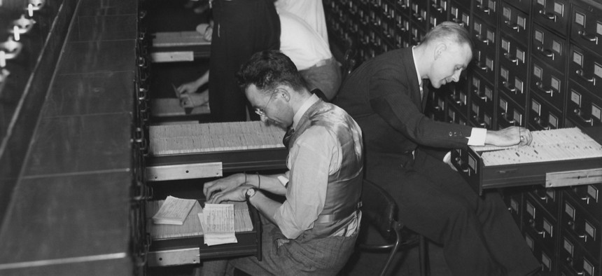 Archival photo of government employees file citizens applications for Social Security numbers, circa 1937.