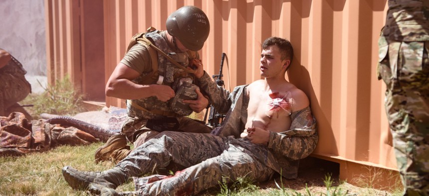 An actor holds onto a medical technician attempting to assist him during the Cannon Air Force Base Medic Rodeo, a training exercise designed to test the skills of Air Force medical technicians in both deployed and home instillation environments.