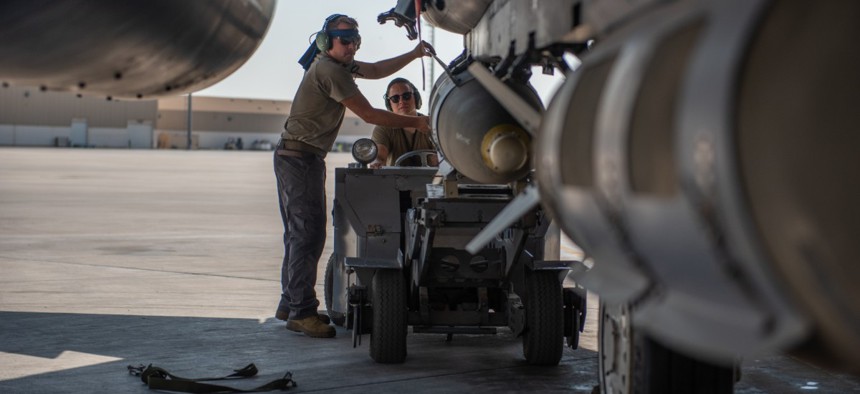380th Expeditionary Aircraft Maintenance Squadron F-15E Strike Eagle weapons load crew members attach a munition to a F-15E at Al Dhafra Air Base, United Arab Emirates.
