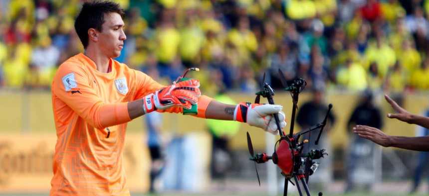 Uruguay's goalkeeper Fernando Muslera picks up a drone which landed on the field during a 2018 World Cup qualifying soccer match in Quito, Ecuador, Thursday, Nov. 12, 2015.
