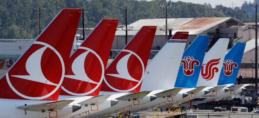 The tails of several of the dozens of grounded Boeing 737 MAX airplanes line the edge of a parking area adjacent to Boeing Field Aug. 15 in Seattle. 