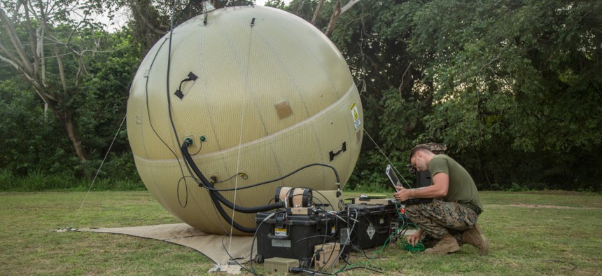 A Marine finalizes adjustments on a ground antenna transmit and receive communications system during the setup of a command operations center in Base de Entrenamiento de Infanteria de Marina, Coveñas, Colombia, in September.