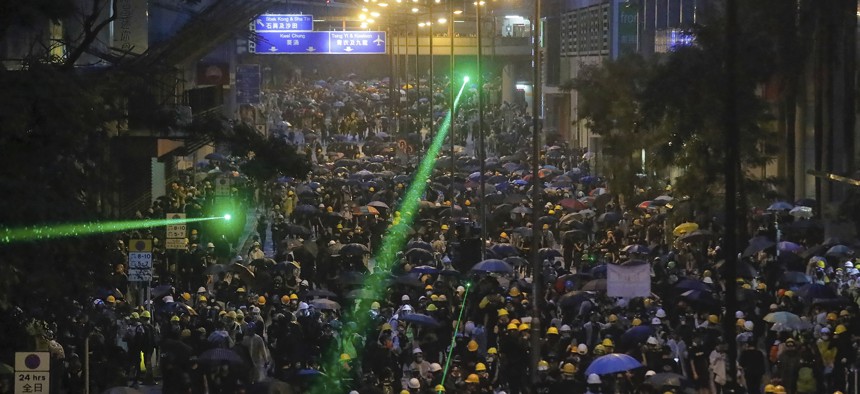 Demonstrators, some using laser pointers toward police lines during a protest in Hong Kong, Sunday, Aug. 25, 2019. 