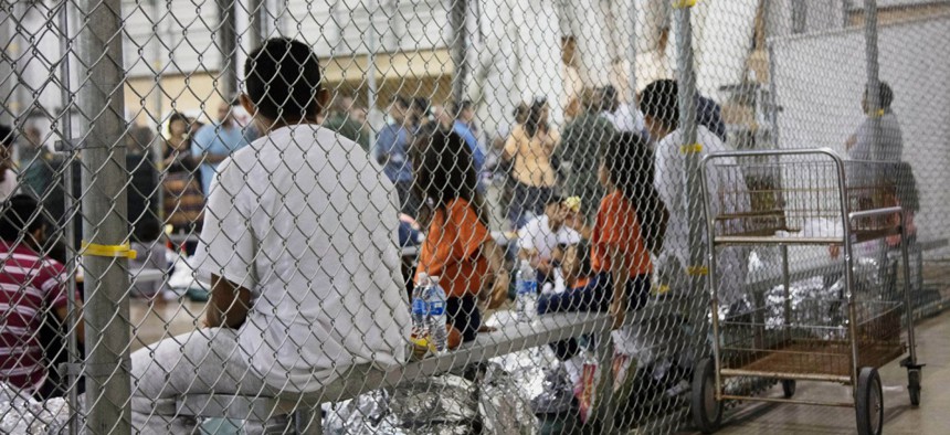 In this June 17, 2018 file photo provided by Customs and Border Protection, people who've been taken into custody related to cases of illegal entry into the United States sit in a facility in McAllen, Texas. 