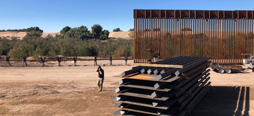 In this Jan. 10, 2020, photo, people work at a portion of border wall which is under construction in Yuma, Ariz.