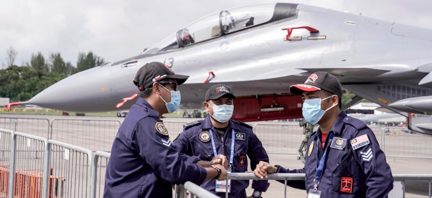 The Royal Malaysian Air Force personnel wear masks at the Static Aircraft Display area at the Singapore Airshow in Singapore Tuesday, Feb. 11, 2020 in Singapore. 