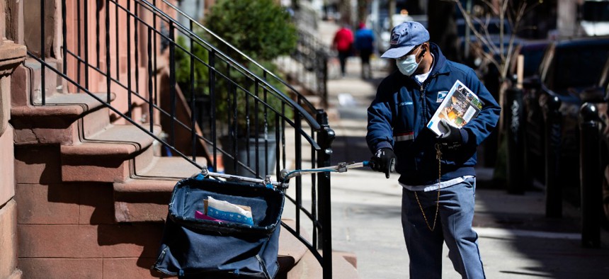 A United States Postal worker makes a delivery with gloves and a mask in Philadelphia April 2.