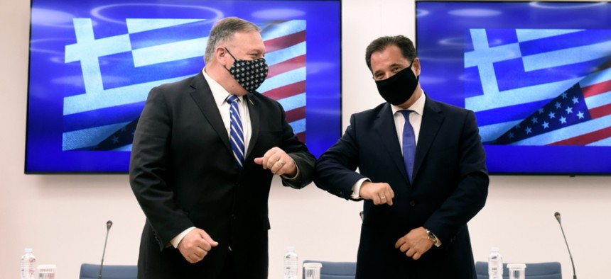 U.S. Secretary of State Mike Pompeo, left, and Greek Minister for Development and Investment Adonis Georgiadis touch elbows during a signing agreement ceremony in the northern city of Thessaloniki, Greece, Sept. 28.