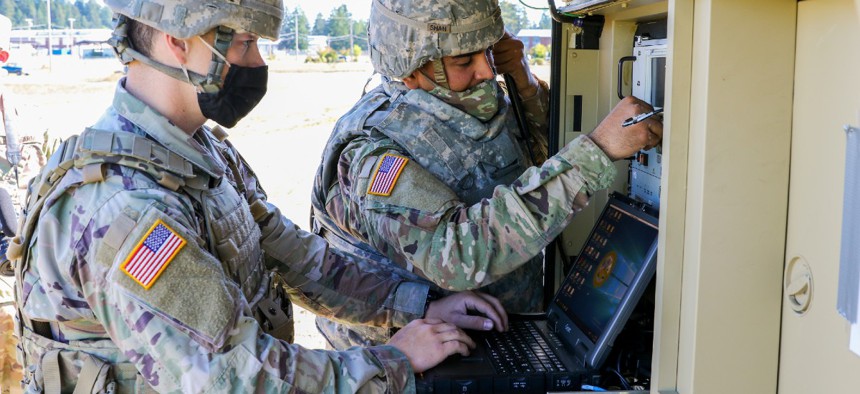 A U.S. Army signal specialist and an information technology Specialist prepare their equipment as part of the Spartan Week Convoy Operations on Sept. 29 at Joint Base Lewis-McChord, Wash. 